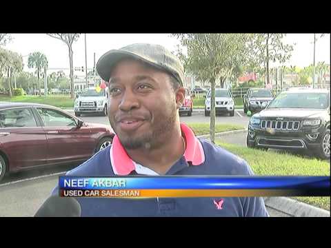 Man takes golf swing at used car salesman