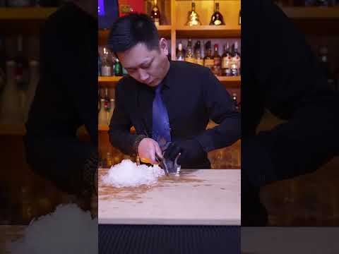 BB Bartender cuts diamond ice with hand cubes to make a cup of mellow and elegant cocktail