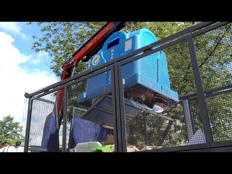 Żuraw śmieciarka podczas pracy. Załadunek makulatury