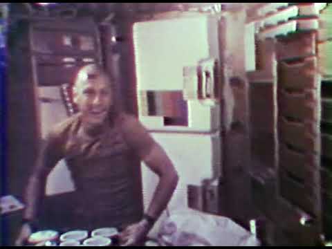 The Skylab 1 crew demonstrates meal time onboard the station, May 29, 1973.