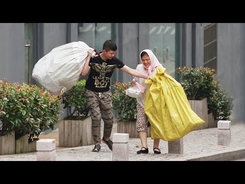 當拾荒老人街頭抬不動重物，有路人一把扛起這兩個袋子