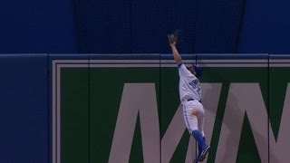Kevin Pillar climbs the wall to rob a homer