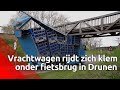 Vrachtwagen rijdt zich klem onder fietsbrug in Drunen