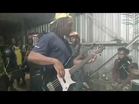 Waleas of Pangia Band's bassist with his fingers on the bass guitar during live performance.