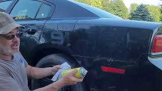 Removing dried decal adhesive from a car.