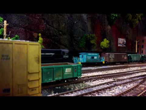 HO Penn Central U- Boats hauling gravel train up grade.