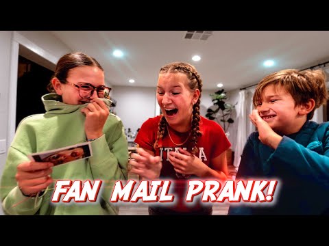 Thumbnail of three kids indoors laughing during a fan mail prank; left kid in green hoodie holds a card, center girl with braids laughs, right boy smiles; bold 'FAN MAIL PRANK!' caption at bottom.