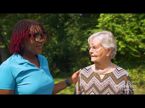 Senior woman in wheelchair enjoying time in the park with caregiver