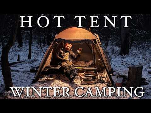 Wintercamping in einem heißen Zelt bei Schnee und eisigen Temperaturen