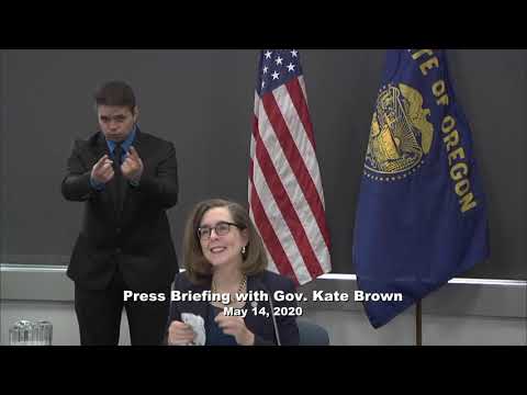 Governor Kate Brown presenting at the May 14th press conference with a sign language interpretor in the background