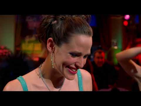 Trailer frame: Jenna in the Poise office where diegetic music sparks the iconic dance