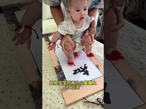 妈妈把宝宝的手脚印在字画上，这创意真是别出心裁