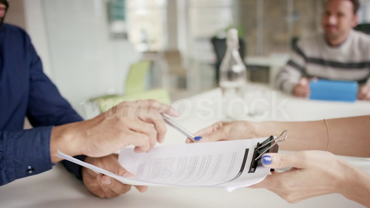 Female executive handing over partnership agreement Businessman signing contract in creative modern