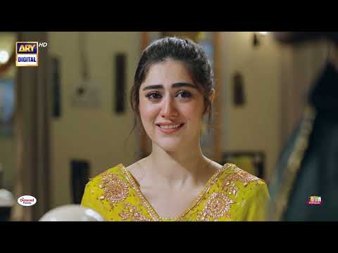 Heer stands in the vibrant courtyard of her home, surrounded by colorful potted plants, looking towards the entrance with a mix of anticipation and grace.