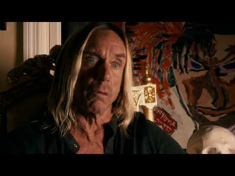 Trailer frame focusing on early Stooges rehearsal photographs used in the documentary