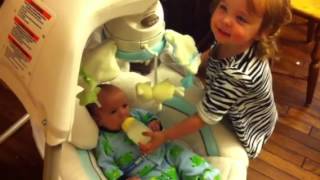 Toddler feeding baby