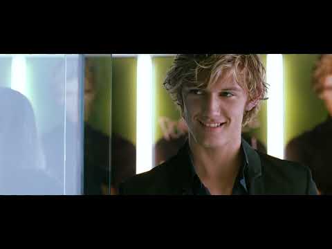 Trailer close-up: greenhouse lights on glass, a piano motif pulsing under the image