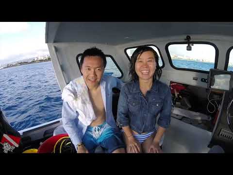 First-time divers descending into clear water off Honolulu, Oahu with dive instructor
