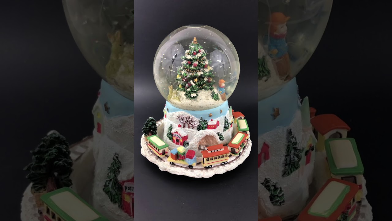 Revolving train around Christmas tree snow globe