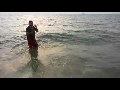 Casting net fishing at Sunset Remis Beach Malaysia