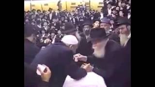 נהג מונית מנשק את ידי הרבי ומקבל שני בקבוקי משקה מהרבי - התמונה מוצגת ישירות מתוך אתר האינטרנט יוטיוב. זכויות היוצרים בתמונה שייכות ליוצרה. קישור קרדיט למקור התוכן נמצא בתוך דף הסרטון