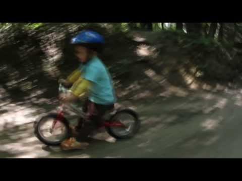 2 years old kid speeding downhill on a bike