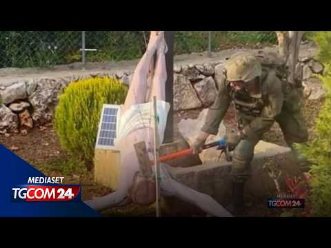 Soldato israeliano colpisce con una mazza la statua di Gesù in croce