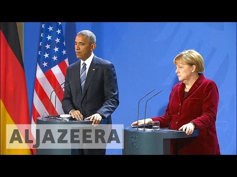 Obama visits Merkel in Germany, prods Trump on Russia