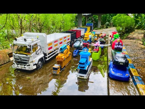 Wow!!! A long truck unloaded a full load of cars, a mixer truck, a forklift, and an ambulance.