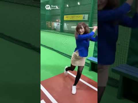 ミニスカート女子アナがバッティングセンターでボールを打ってから笑顔で腰を下ろす場面