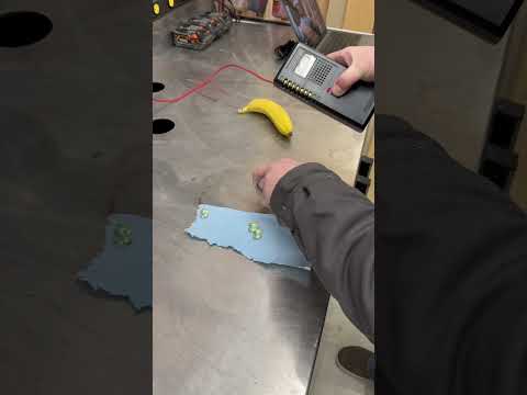 Geiger counter against banana, green glass, uranium ore, and a 1930s Fiestaware plate