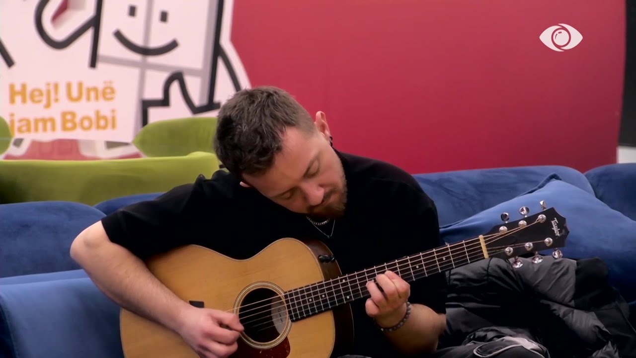 Tiri i bie kitarës, ndërsa banorët e shoqërojnë duke kënduar