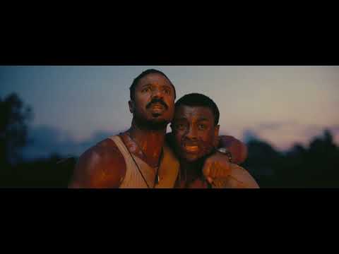 Sinners movie official trailer still: smoky 1930s juke joint with stage lights