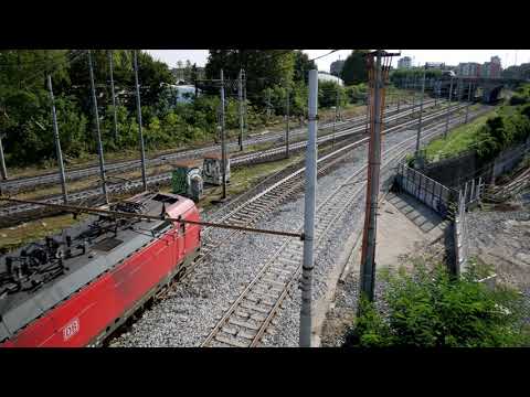 Freight train hauled by locomotive 193 332 passes a Trenord regional train in Milan Forlanini, Octob