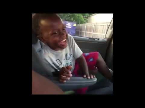 Black kid laughing in car