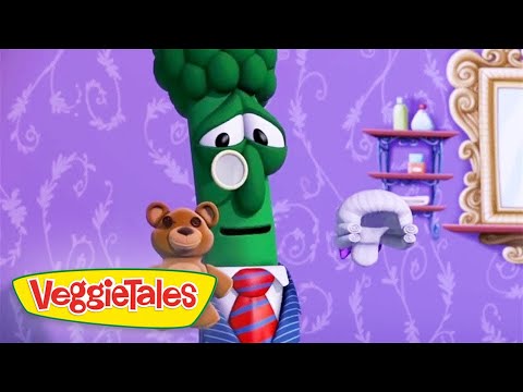 Green broccoli character in a suit holding a teddy bear, with the VeggieTales logo on a purple patterned background.