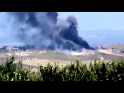 تصاعد الدخان من أحد مستودعات الذخيرة في قرية الطليسية بعد استهدافها من قبل كتيبة البراء المقاتلة في ريف حماة