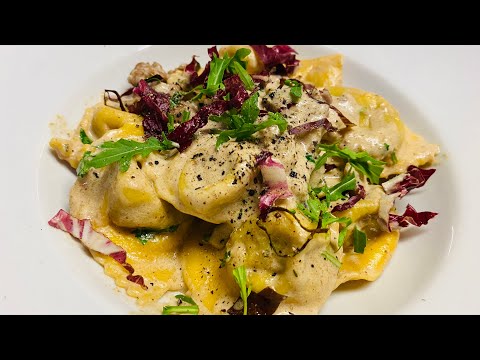 Pasta ripiena di porcini condita con salsiccia crema tartufata radicchio e rucola