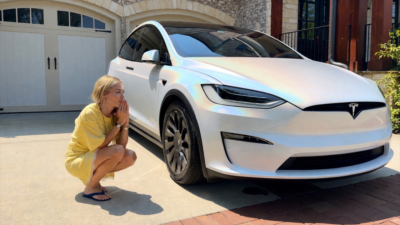 Tesla Model X being fitted with an iridescent vinyl wrap in a workshop