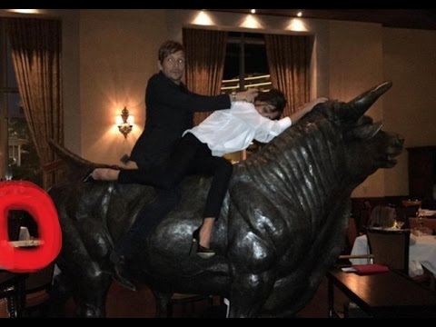 Victoria Beckham shows her fun side as she mounts a sculpture in a Las Vegas steakhouse