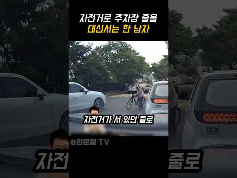 자전거로 주차장 줄을 대신서는 한 남자
