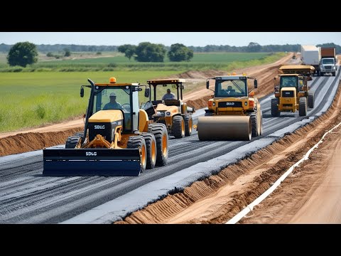 Amazing road construction in a rural area. The large yellow motor grader is working on a dirt road