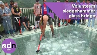 Volunteers sledgehammer glass bridge to test strength