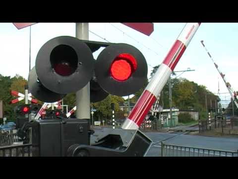 TRAIN PASSES BY VERY QUICKLY AT RAILROAD CROSSING / Spoorwegovergang in Bilthoven