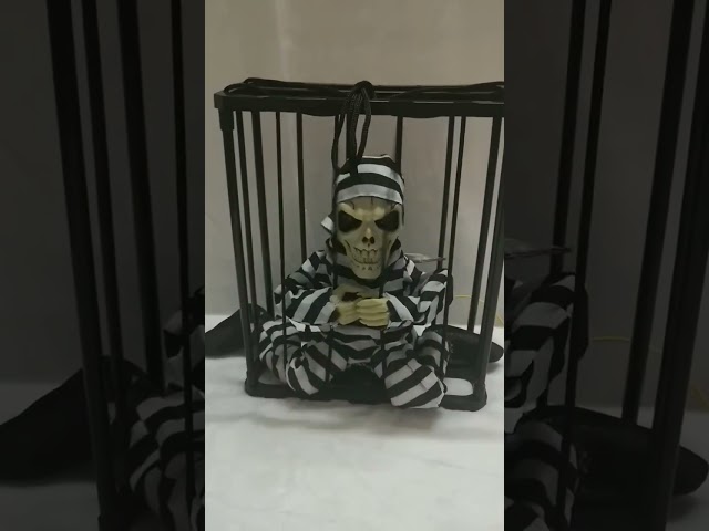 Vídeo relacionado con Animatronics de Halloween - Prisionero de Jaula de Calavera con Ojos iluminados Colgantes, Esqueleto Animado Activado por Sensor de Movimiento para Patio de Fiesta en casa encantada