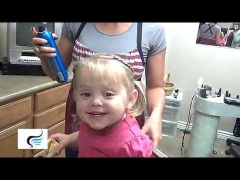 Little girl smiling with pigtails, styled by an adult, showcasing a playful hairstyle tutorial for kids.