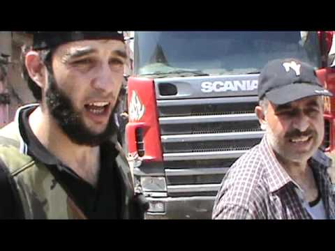 الملازم مرشد الخالد يساعد في اطفاء حريق نشب في أحد أحياء الأتارب في ريف حلب الغربي