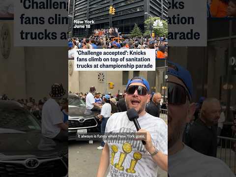 Knicks fans climb on top of NYC sanitation trucks parked outside the championship parade route