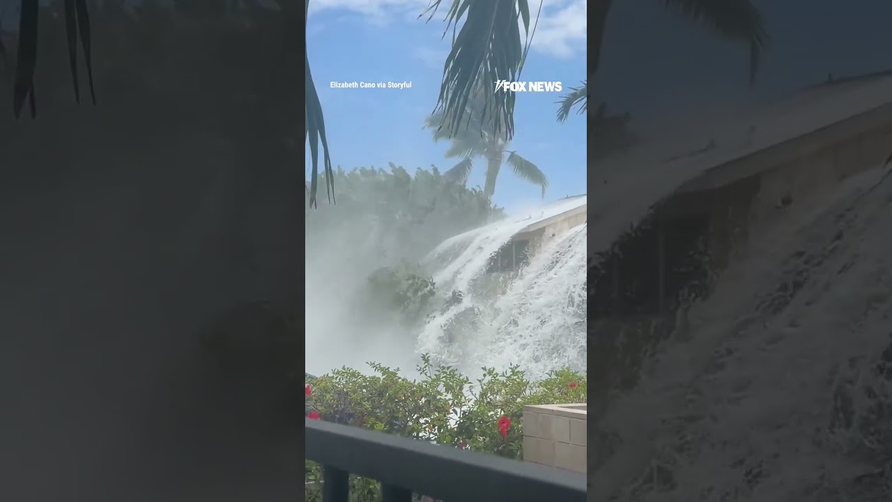 Large wave crashes over Hawaii oceanfront condominium rooftop, ripping away shingles