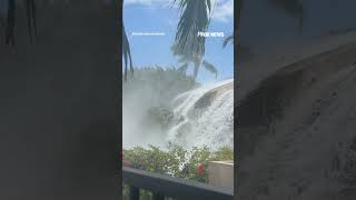 Large wave crashes over Hawaii oceanfront condominium rooftop, ripping away shingles